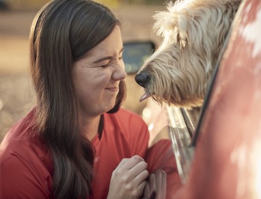 Plasma recipient Hayley and her dog by a red car