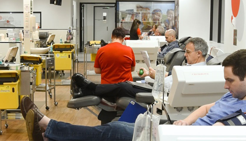 a donor centre with various donor seated in chairs