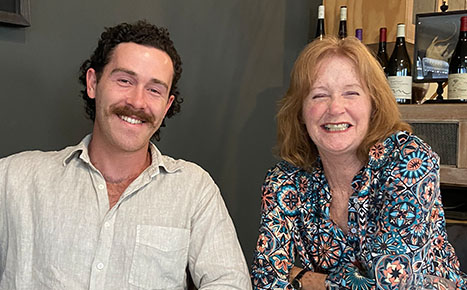 man and woman seated in a restaurant smiling at the camera