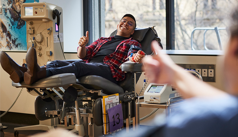 image of a male donor in the chair smiling and holding up a thumbs up sign