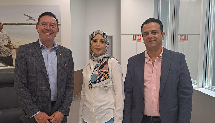 Two men and a woman posing for camera 