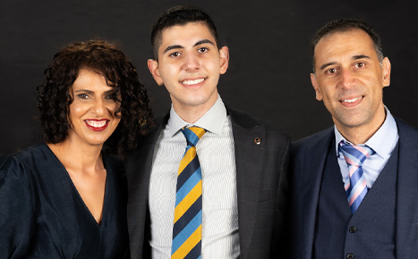 image of a teenage boy with his parents smiling at the camera