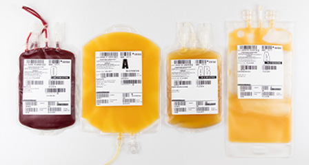 Four blood component bags arranged in a row on a light background.