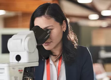 Lifeblood female laboratory technician looking in microscope