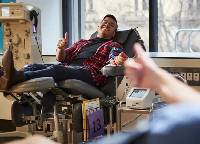 image of a male donor in the chair smiling and holding up a thumbs up sign