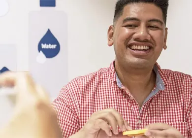 a man holding a cracker with cheese and smiling