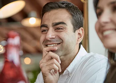 a man seated at restaurant table smiling