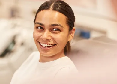 a woman seated in a donor chair smiling