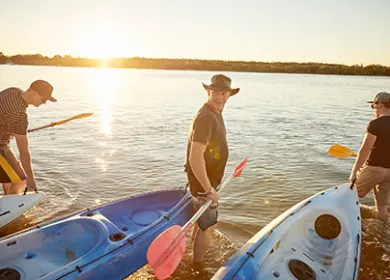 Men carrying kayaks into water