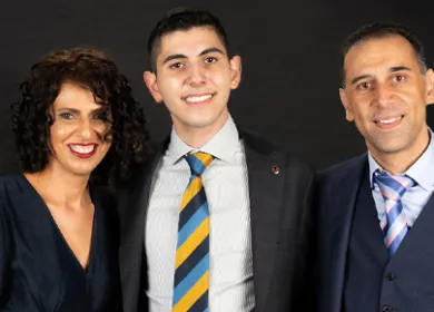 image of a teenage boy with his parents smiling at the camera