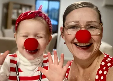 a baby and woman wearing red noses and laughing