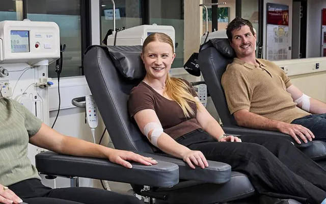 three donors smiling and seated in chairs during a donation with a nurse to their side