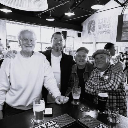 4 men smiling in a bar