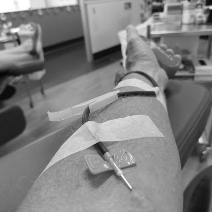 man donating showing the needle in his arm