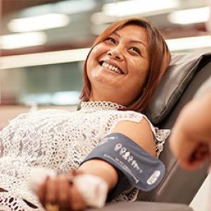 photo of a donor lying back in a chair having her blood pressure taken