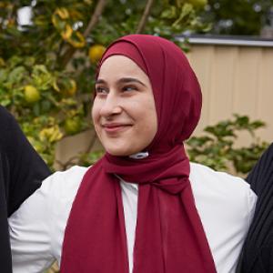 woman in red hijab looking to her right and smiling